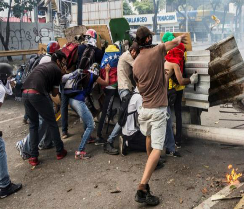 Manifestantes de oposição enfrentam a Guarda Nacional Bolivariana nos protestos da greve geral  (Nathalie Sayago/EFE/Agencia Brasil)